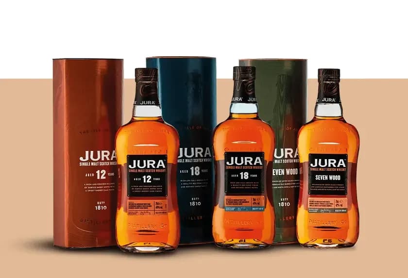 Three bottles of Jura whisky and their boxes: 12-year, 10-year, and Seven Wood.